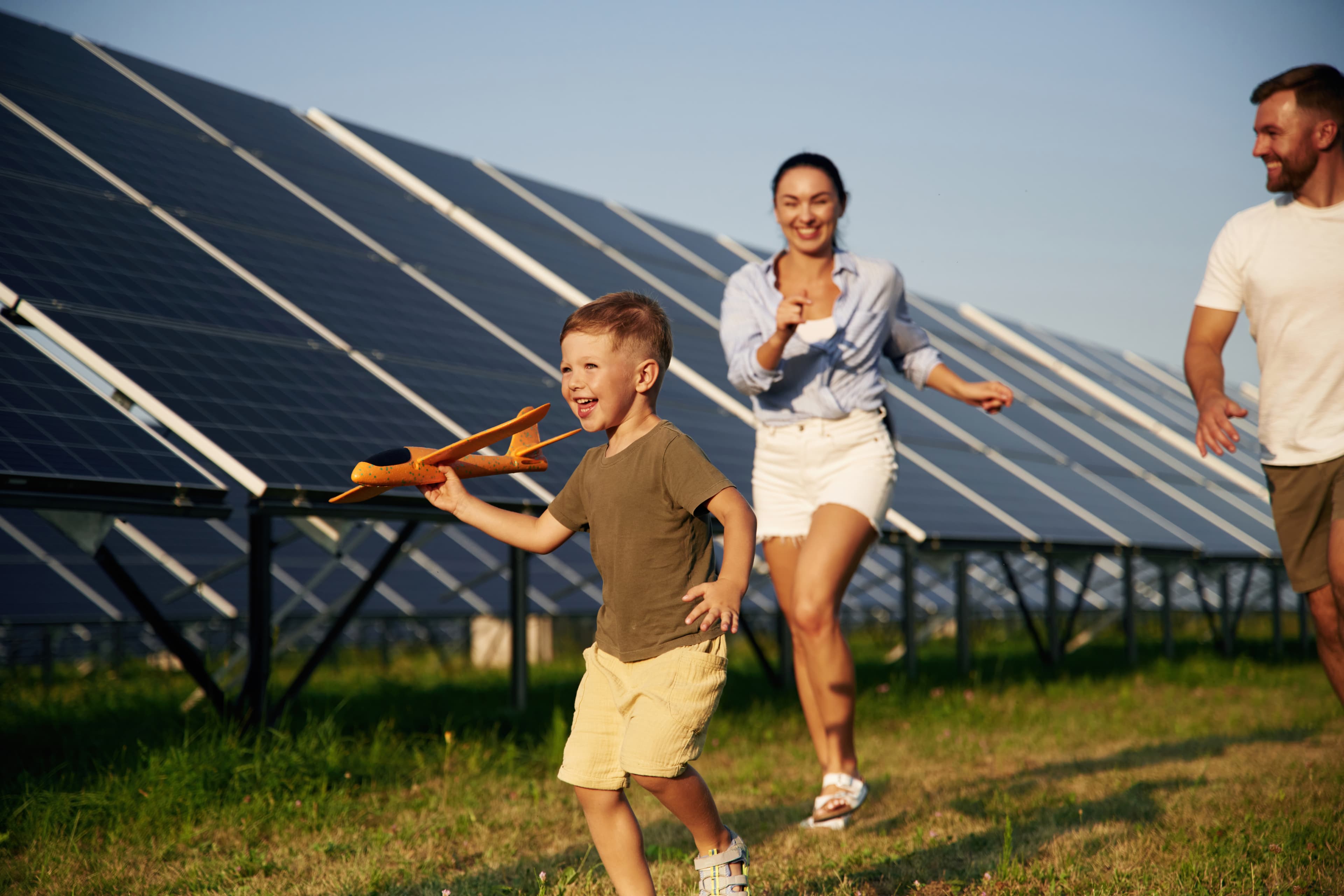 Família correndo em frente a painéis solares